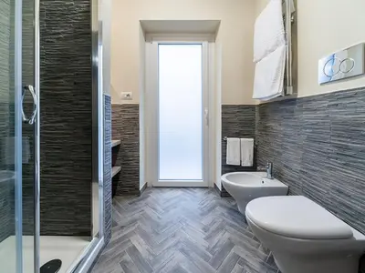 a bathroom with a toilet and a sink and a shower at Foro Romano Luxury Suites in Rome