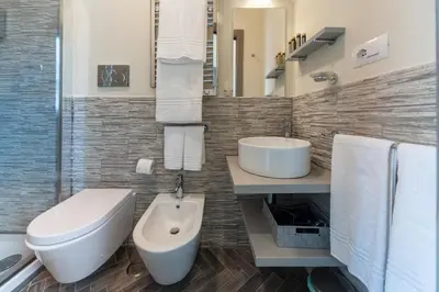 a bathroom with a toilet and a sink at Foro Romano Luxury Suites in Rome