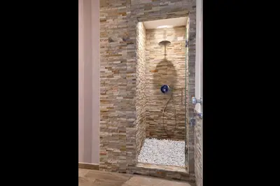 a bathroom with a shower in a brick wall at Veneto Suite Rome in Rome