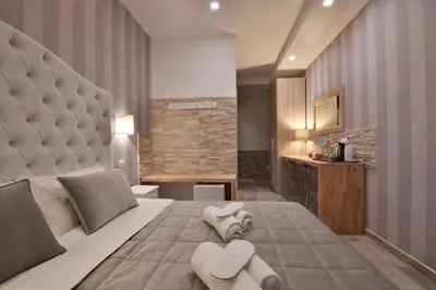 a bedroom with a large bed with a large headboard at Veneto Suite Rome in Rome