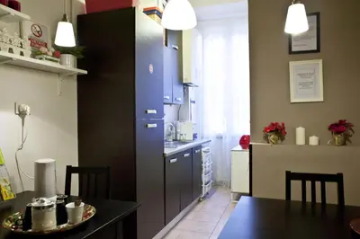 a kitchen with a blue refrigerator and a table in it at Happy Stay Guesthouse in Rome