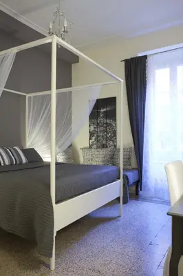 a bedroom with a canopy bed and a window at Happy Stay Guesthouse in Rome