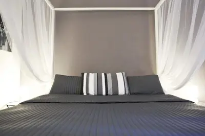 a bed with a blue and white striped pillow on it at Happy Stay Guesthouse in Rome