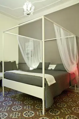 a bedroom with a canopy bed with curtains at Happy Stay Guesthouse in Rome