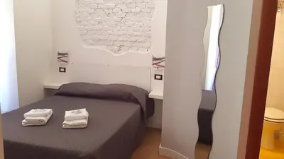 a bedroom with a bed with two towels on it at Piumith Guest House in Rome
