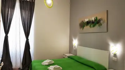 a bedroom with a green bed and a window at Piumith Guest House in Rome