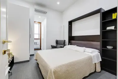 a bedroom with a large bed and a chair at Affreschi Su Roma Luxury B&B in Rome