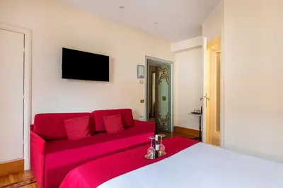 a red bed with a red couch in a room at Martina House in Rome