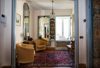 a living room with a chair and a mirror at Martina House in Rome