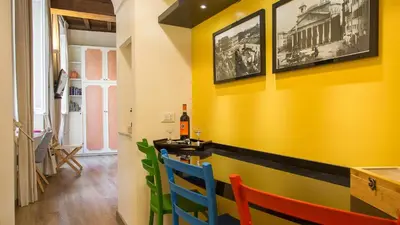 a dining room with yellow walls and colorful chairs at Leutari Suite in Rome