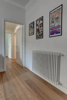 an empty room with a radiator and posters on the wall at La Casa Sui Fori in Rome