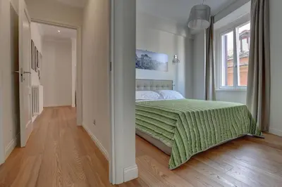 a bedroom with a bed with a green comforter at La Casa Sui Fori in Rome