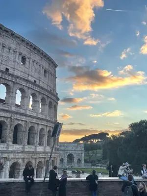 a group of people sitting in front of the coliseum at La Casa Sui Fori in Rome