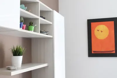a room with white shelves and a painting at BenS'Houses - Villa Pamphili apartment in Rome