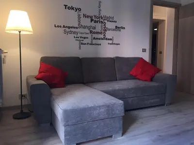 a couch with two red pillows in a living room at BenS'Houses - Villa Pamphili apartment in Rome