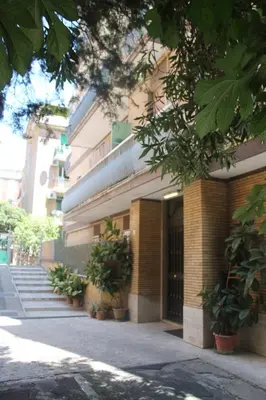 a building with potted plants in front of it at BenS'Houses - Villa Pamphili apartment in Rome