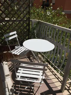 a white table and two chairs on a balcony at BenS'Houses - Villa Pamphili apartment in Rome
