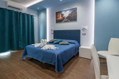 a blue bedroom with a bed with a blue blanket at World Wide Bed - Prenestino in Rome