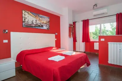 a red bedroom with a bed with a red wall at World Wide Bed - Prenestino in Rome