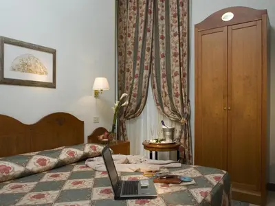 a hotel room with a laptop on a bed at Hotel Aberdeen in Rome