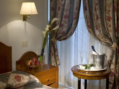 a bedroom with a table with a vase of flowers and a window at Hotel Aberdeen in Rome