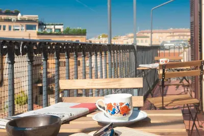 a cup of coffee sitting on a table on a balcony at Monti Deluxe - Terrace Spectacular View in Rome