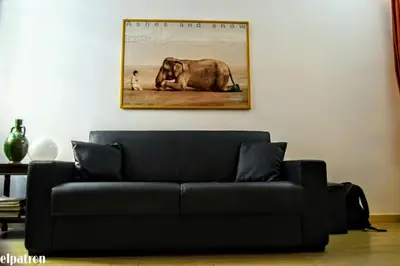 a black couch in a living room with a picture of an elephant at barberini holiday house in Rome