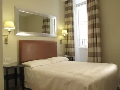 a bedroom with a bed with a mirror and a window at Hotel Albergo Santa Chiara in Rome