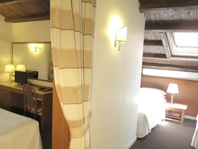 a hotel room with a bed and a desk and a mirror at Hotel Albergo Santa Chiara in Rome