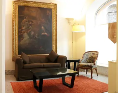 a living room with a couch and a painting on the wall at Hotel Albergo Santa Chiara in Rome
