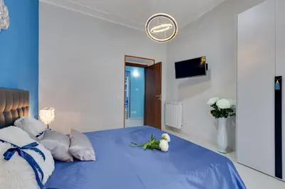 a bedroom with a blue bed with a teddy bear on it at Louise at Colosseum in Rome