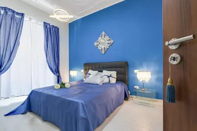 a blue bedroom with a bed with blue walls at Louise at Colosseum in Rome