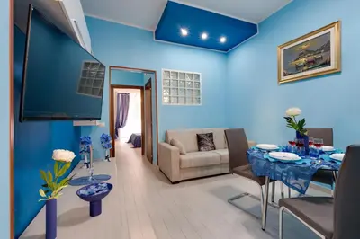 a blue living room with a table and a couch at Louise at Colosseum in Rome