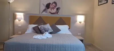a bedroom with a bed with red and white pillows at Vatican View Rooms in Rome