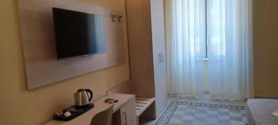 a room with a tv on the wall next to a window at Vatican View Rooms in Rome