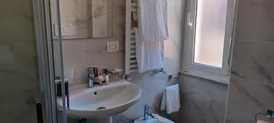 a bathroom with a sink and a toilet and a window at Vatican View Rooms in Rome