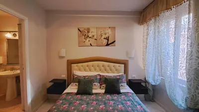 two beds in a bedroom with white walls and a window at B&B Andy&LU in Rome