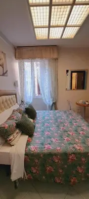 two beds in a white room with flowers on them at B&B Andy&LU in Rome
