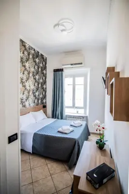 a bedroom with a bed and a window and a table at Hotel Dell'Urbe in Rome