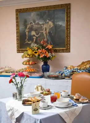 a table with food and a painting on the wall at Hotel Rimini in Rome