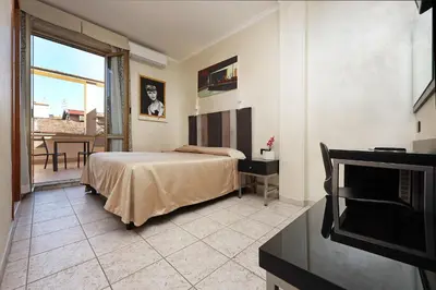 a bedroom with a bed and a balcony at Hotel Rimini in Rome