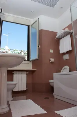 a bathroom with a sink and a toilet and a window at Hotel Rimini in Rome
