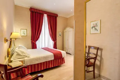 a hotel room with a bed and a desk and a window at Roman Terrace in Rome