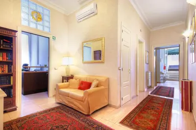 a living room with a chair and a mirror at Roman Terrace in Rome