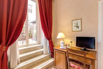a room with a desk with a television and a window at Roman Terrace in Rome