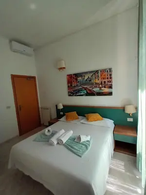a bedroom with a white bed with towels on it at Hotel Castelfidardo in Rome