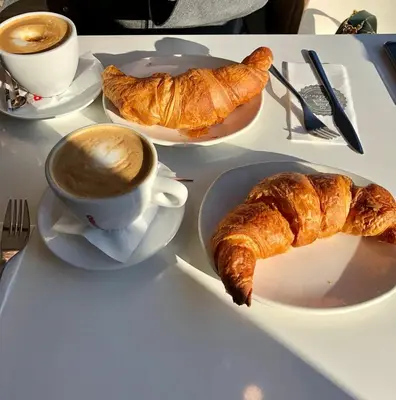 a table with a cup of coffee and croissants on it at Hotel Castelfidardo in Rome