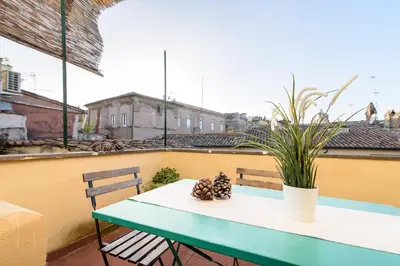 a green and white table on a balcony with a plant at White terrace apartment navona in Rome