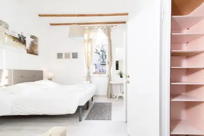 a bedroom with white walls and pink shelves at White terrace apartment navona in Rome