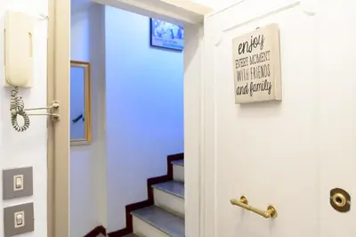 a door with a sign in a hallway with stairs at White terrace apartment navona in Rome